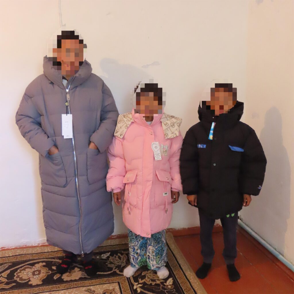 Mother and two children wearing new winter coats